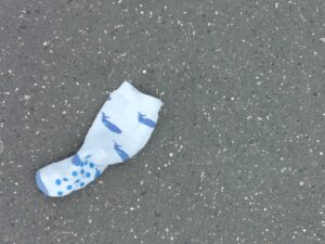 Une chaussette pour enfant à motif de baleines sur le bitume